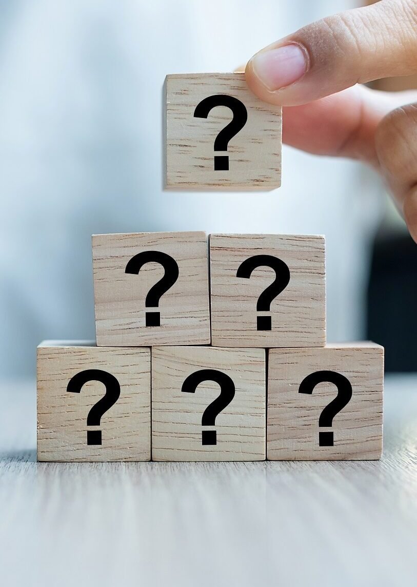 Businesswoman hand placing or pulling Questions Mark ( ? ) word